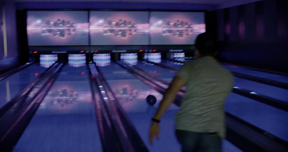 A man throws a gutter ball while bowling