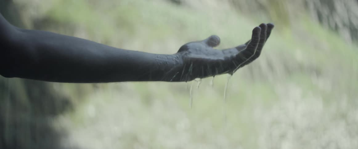 Rain falls on an outstretched arm