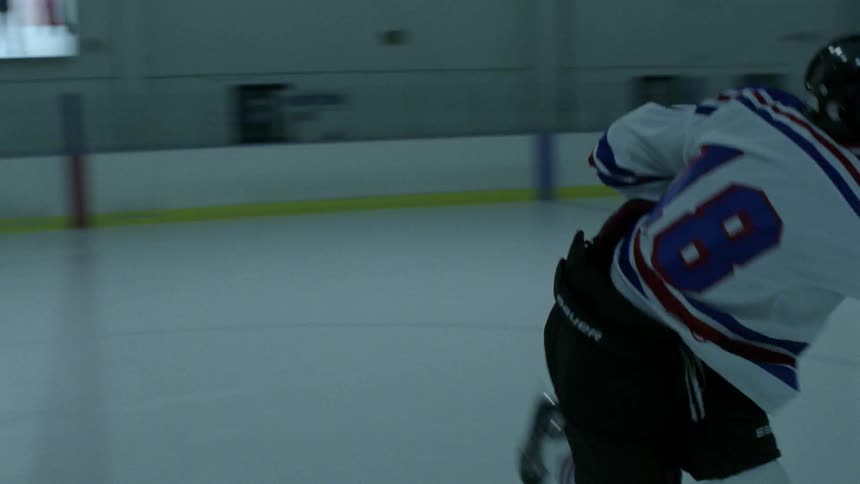 Man on a hockey rink practices swinging hockey stick