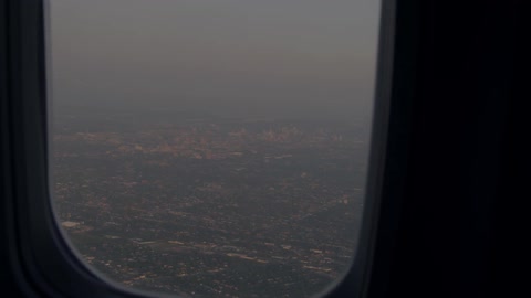 Outside the plane window is a town below