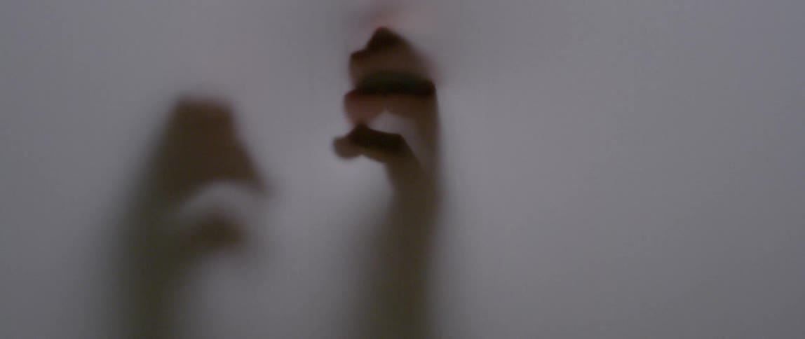 Person moves their hands behind a white screen