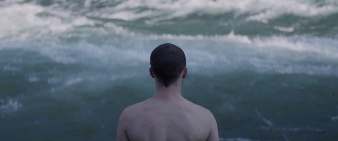 Man stands on beach overlooking the ocean