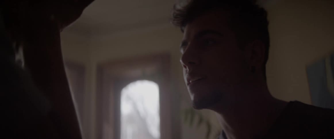 A man yells at another person in a house