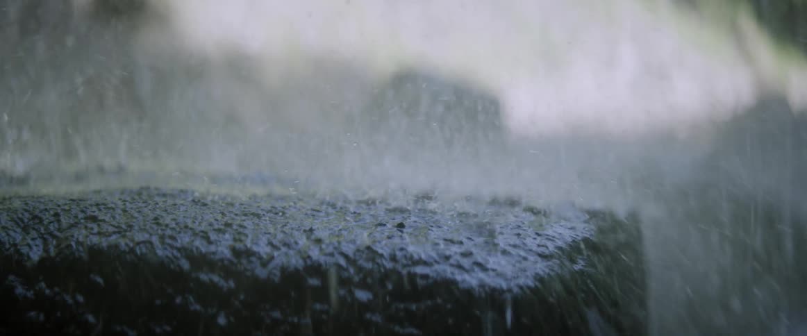 Rain falls onto a slab of asphalt