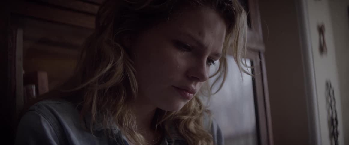 A woman is looking down crying