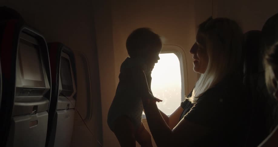 A woman is sitting on a plane with a baby