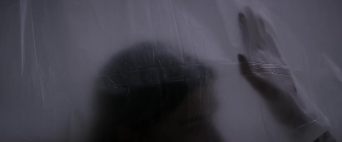 Woman touches a hanging plastic sheet