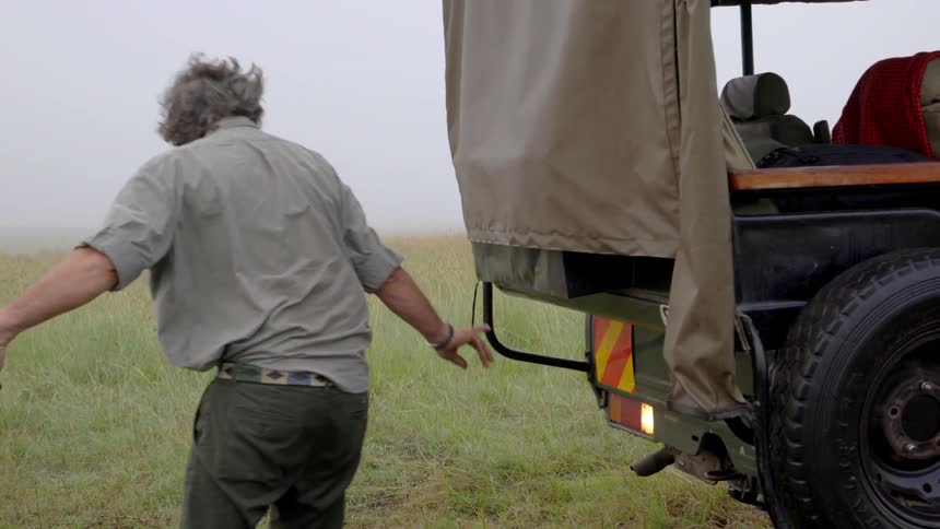 A man attaches a tow rope to a vehicle