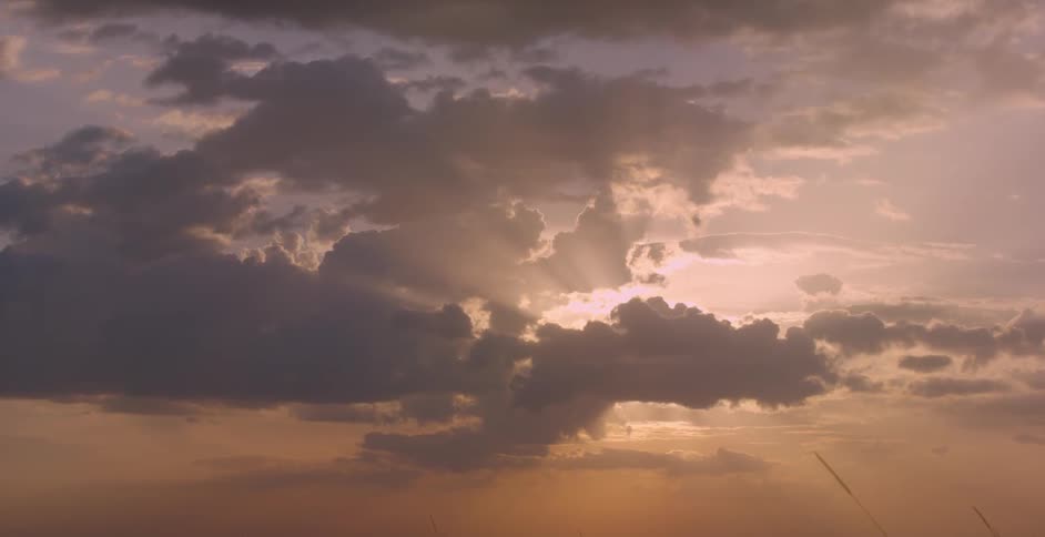 The sun shines through sparse clouds in the sky
