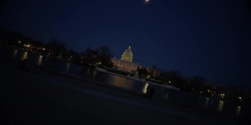 A capitol building illuminates the night sky