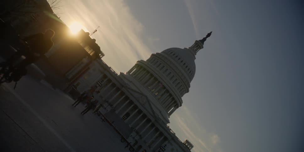 Pedestrians walk on the mall in front of the us capitol building at dusk