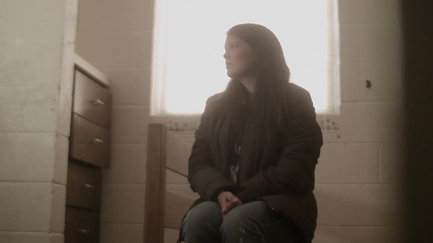 A woman sits in a shelter thinking