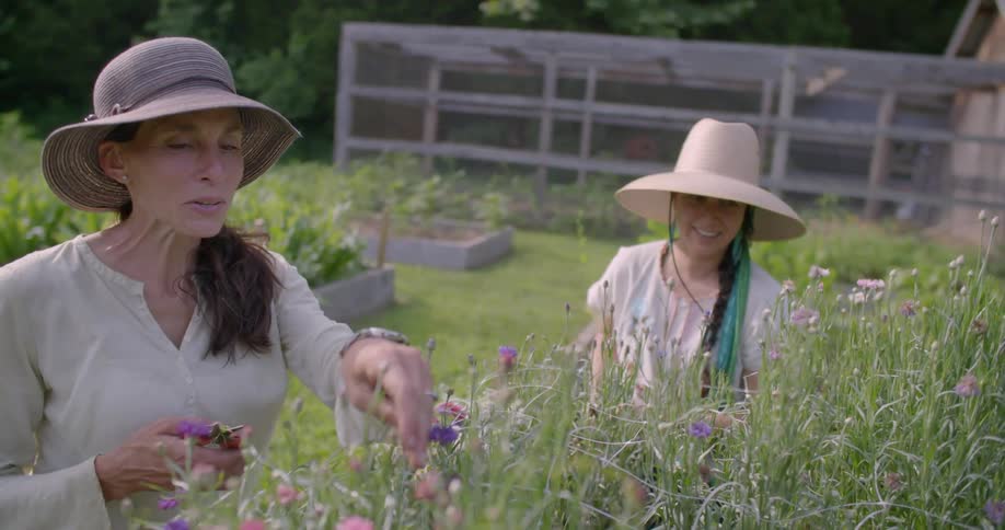 Two woman are laughing and pruning their garden