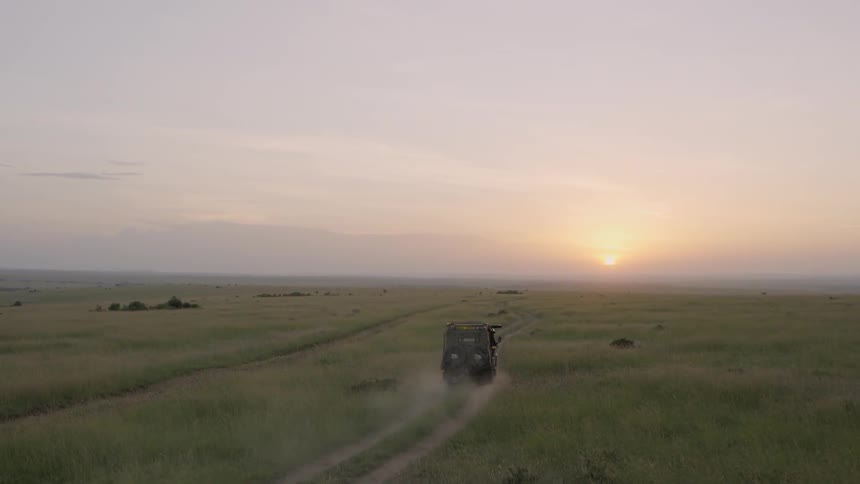 A truck drives down towards the setting sun