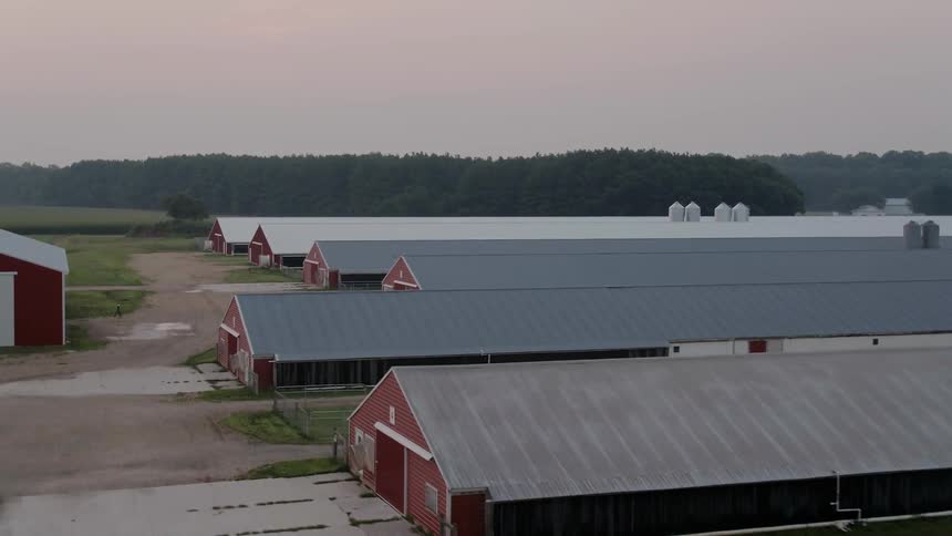 Buildings are shown on a farm at sunset