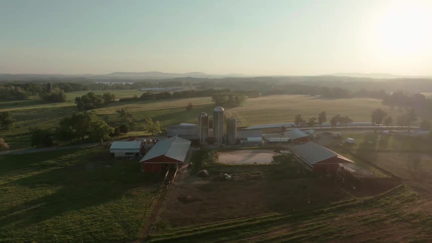 The sun sets over a farm
