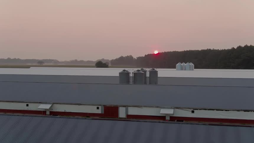 Silos sit between rows of long barns