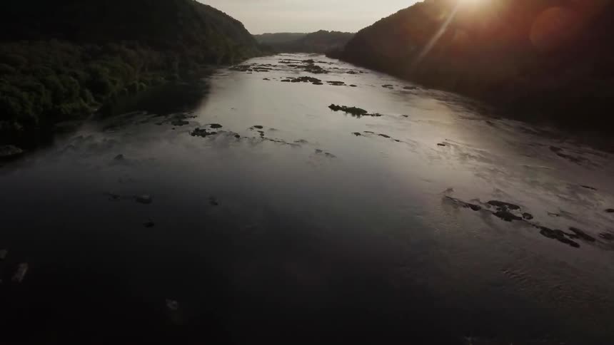 The sun sets over a mountain river