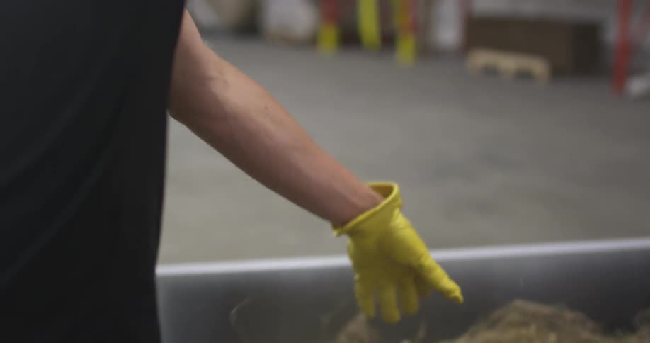 A person pulls hay from a bin
