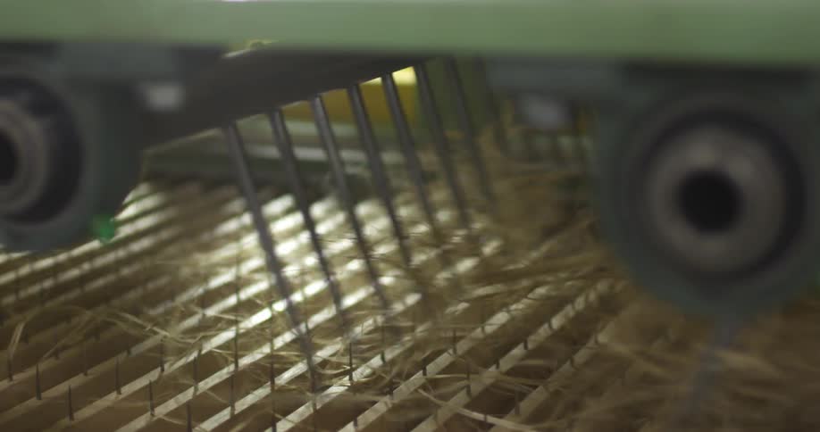 A machine swirling strings above spikes