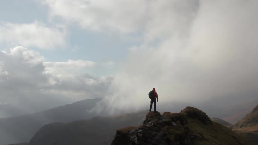 A hiker stops to enjoy the mountain view