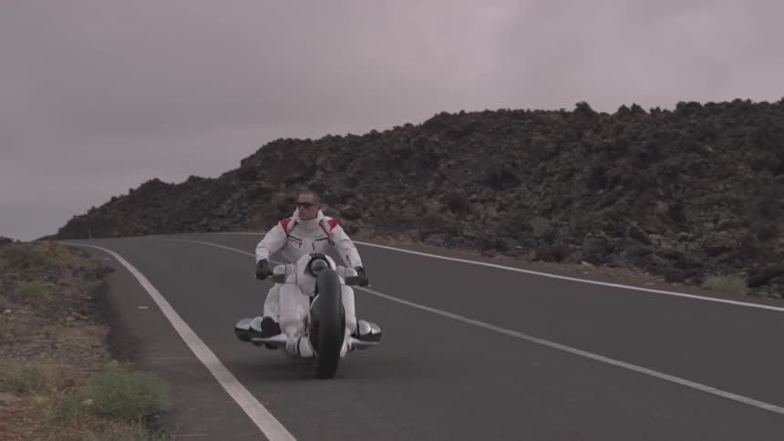 Motorcyclist rides on rural road at sunset