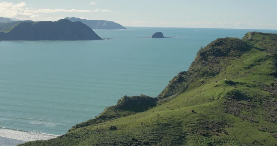 The green cliff leads to the beach below