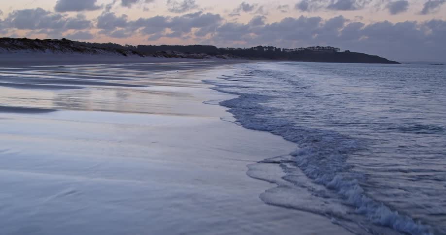 Waves flow onto the beach shore