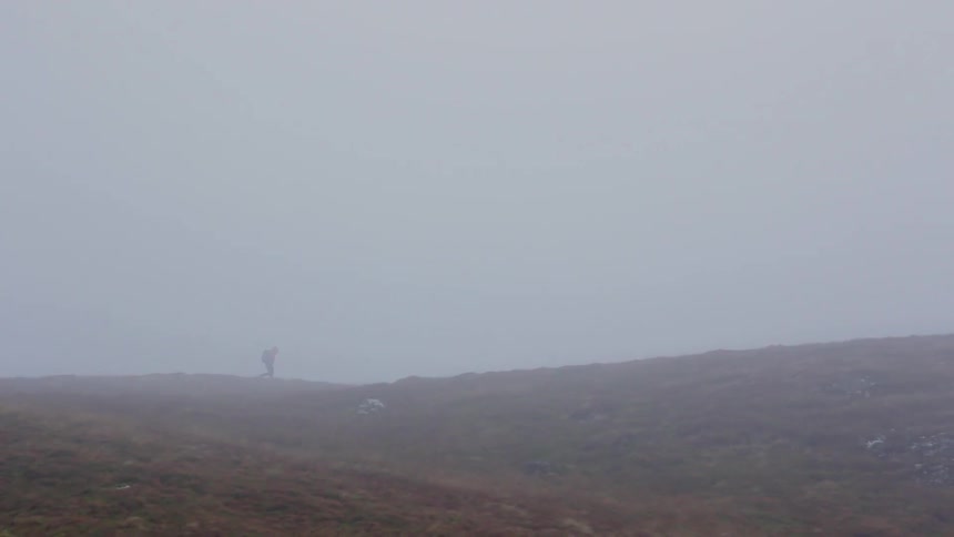 A person is hiking in the mist