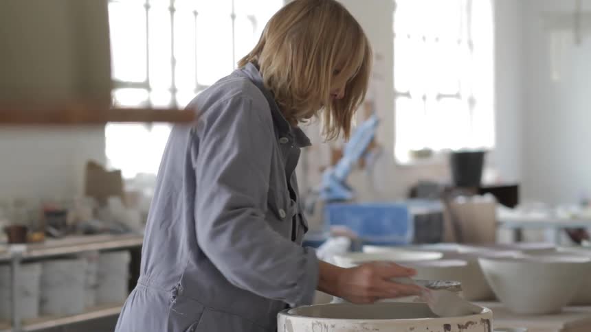 A person paints the inside of a bowl