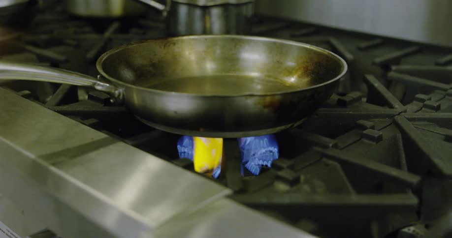 Someone cooks on a large stove