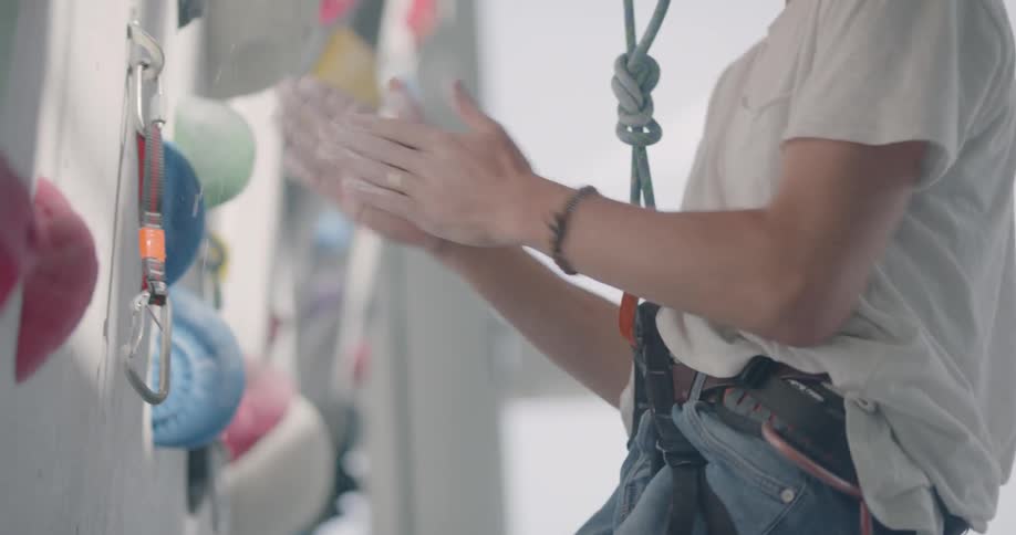 A man rubs his hands together as he prepares to rock climb