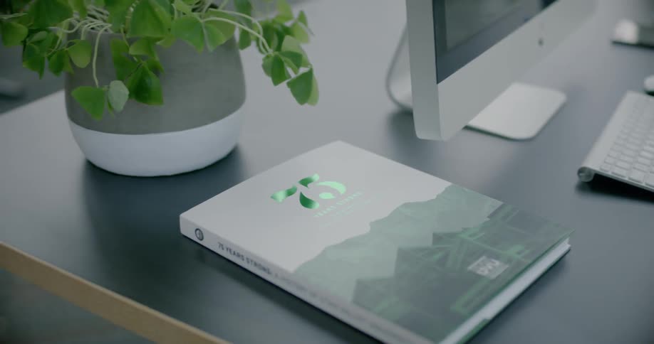 A book with green title text sits on a desk