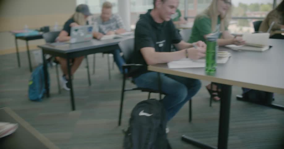 Men and women open books at desks
