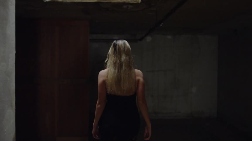 A woman walks through a concrete building