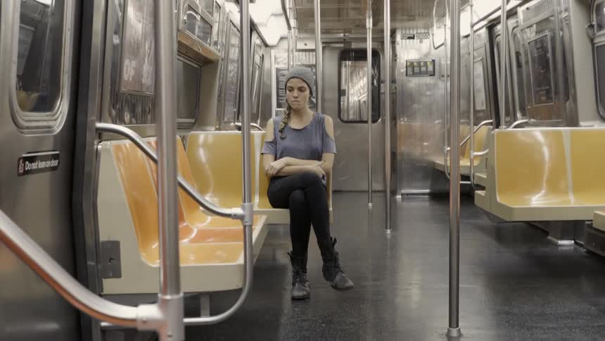 A woman sits on the train waiting for her stop