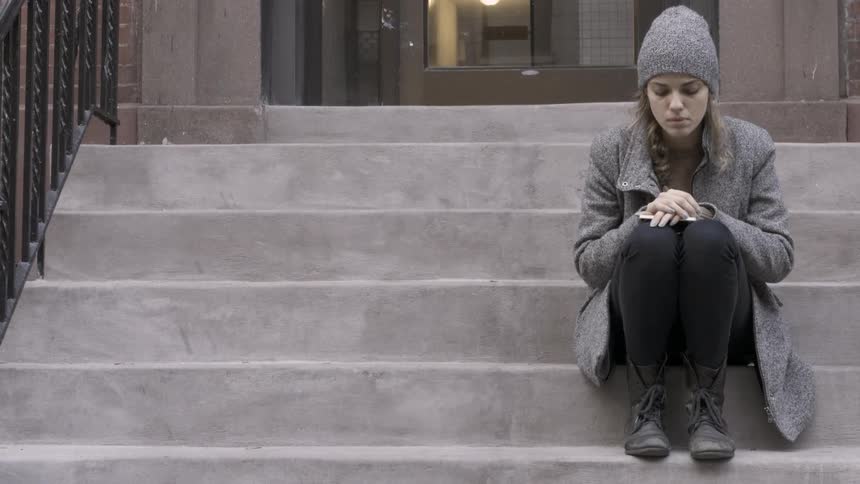 A woman is talking as she sits on the steps