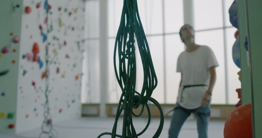 Man walking and looking upwards in climbing wall facility