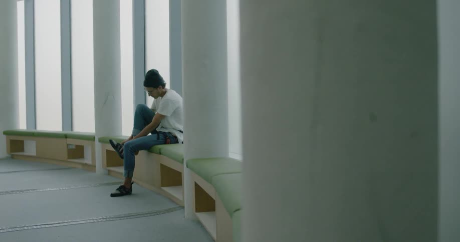 Man sits on a bench and puts on her shoe