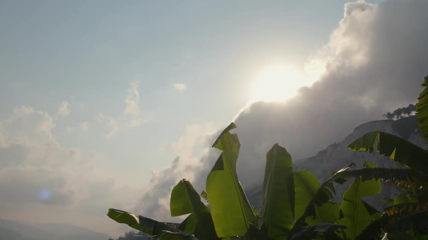 Clouds hover above the mountains on a tropical island during the day