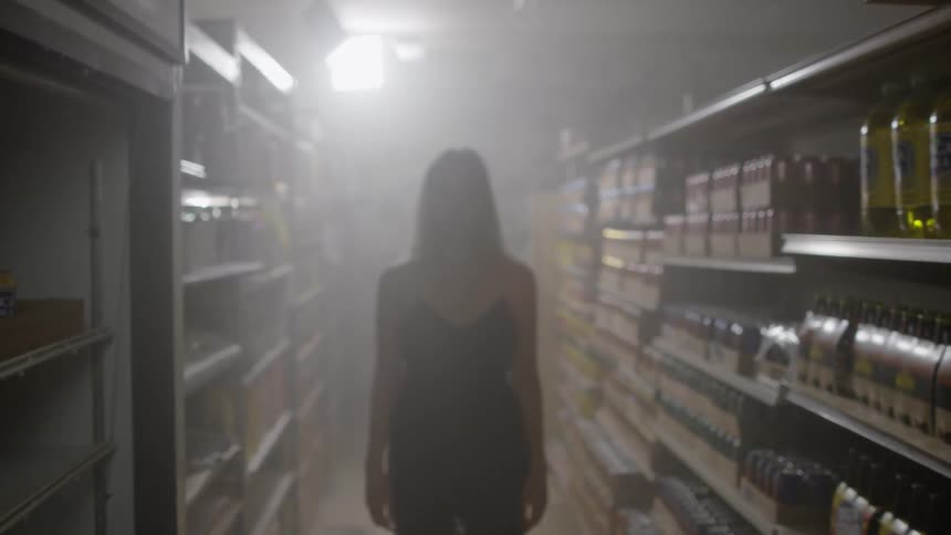 Woman stands unmoving in grocery store aisle