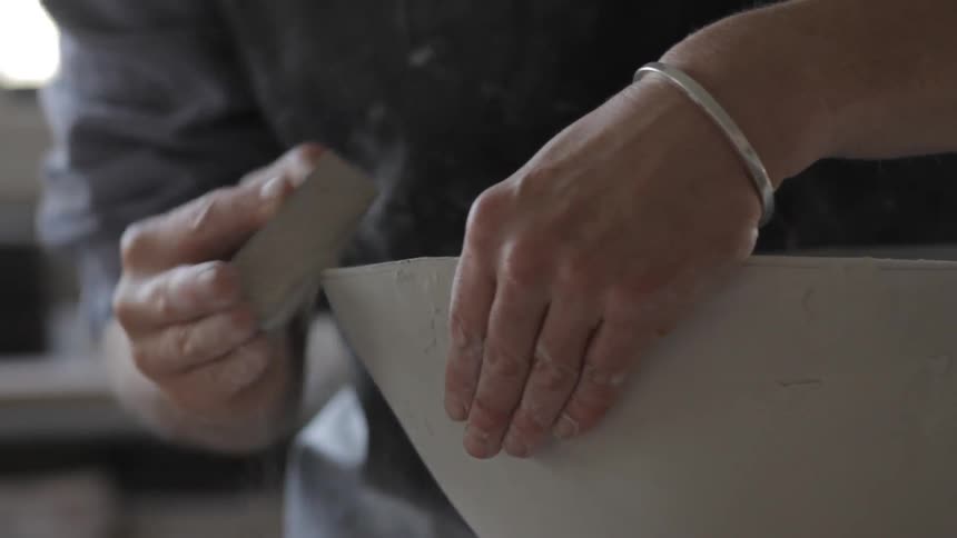 A man sanding the side of an object