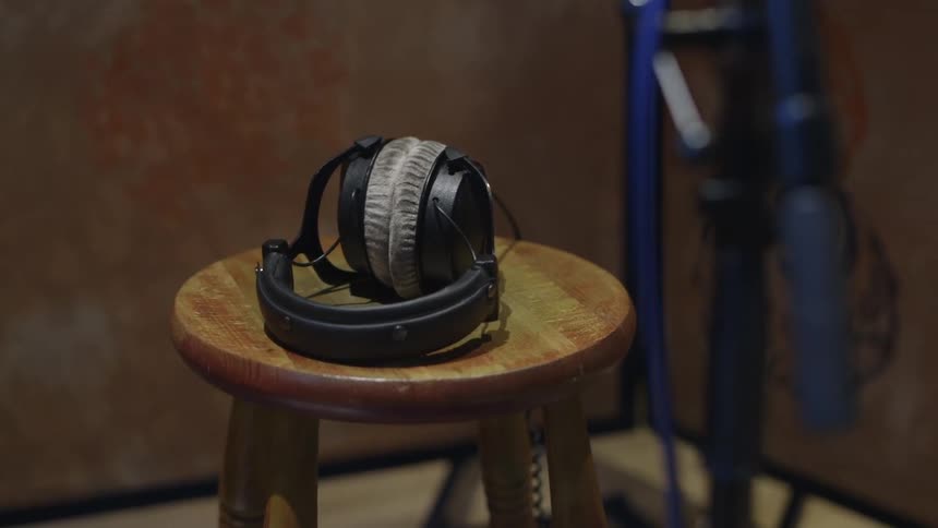Headphones sit on a wooden stool