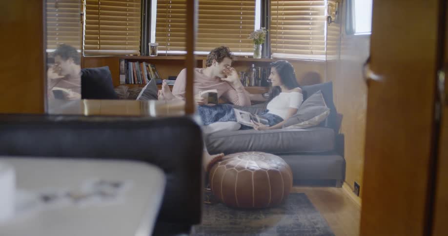 Couple sit on couch in trailer and talk