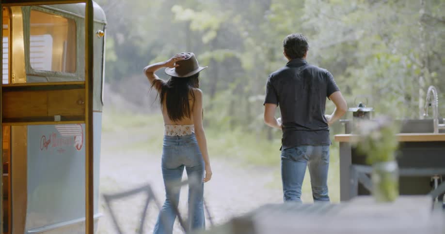A man waits for a woman to exit their camper