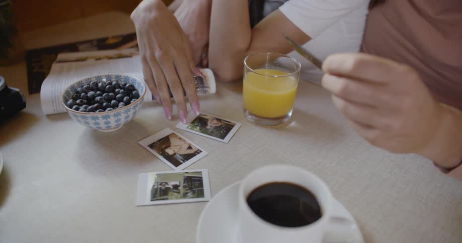 Man and woman sitting at table and looking through photographs