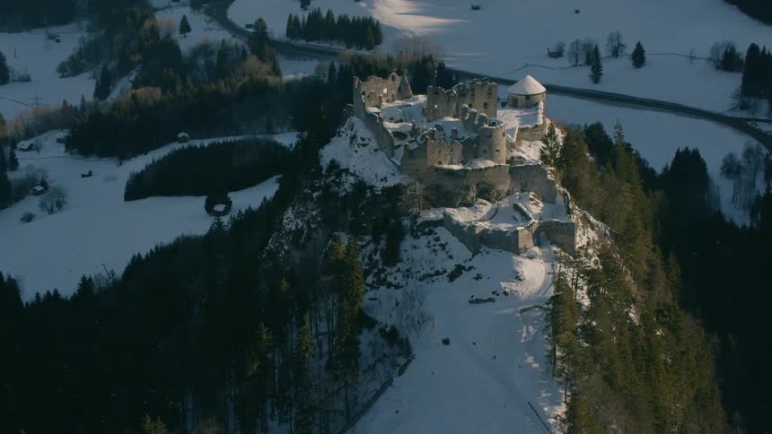 A castle sits in snowy mountains
