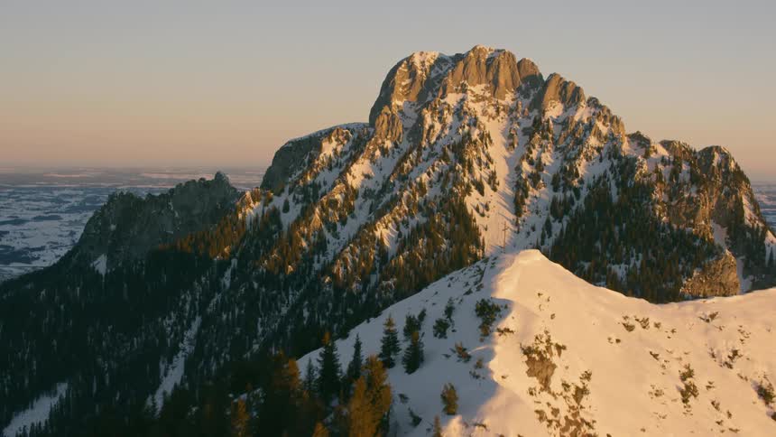 Dusk is casting shadows on a snow-covered mountain