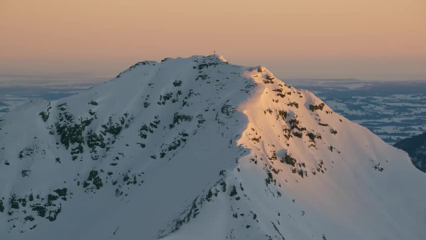 Large snow covered mountain top at sunset
