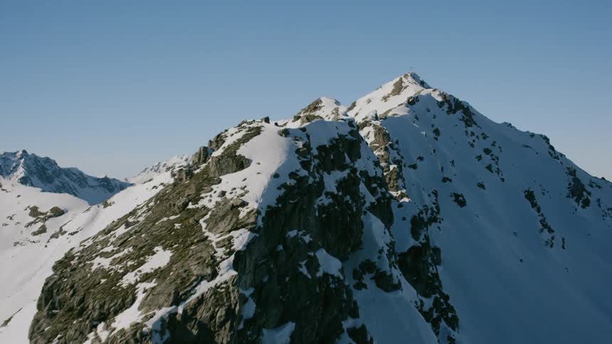 Snow covers a rocky mountain ridge